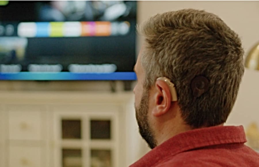Michael Forzano, Amazon Software Engineer, users Cochlear implant while watching tv.